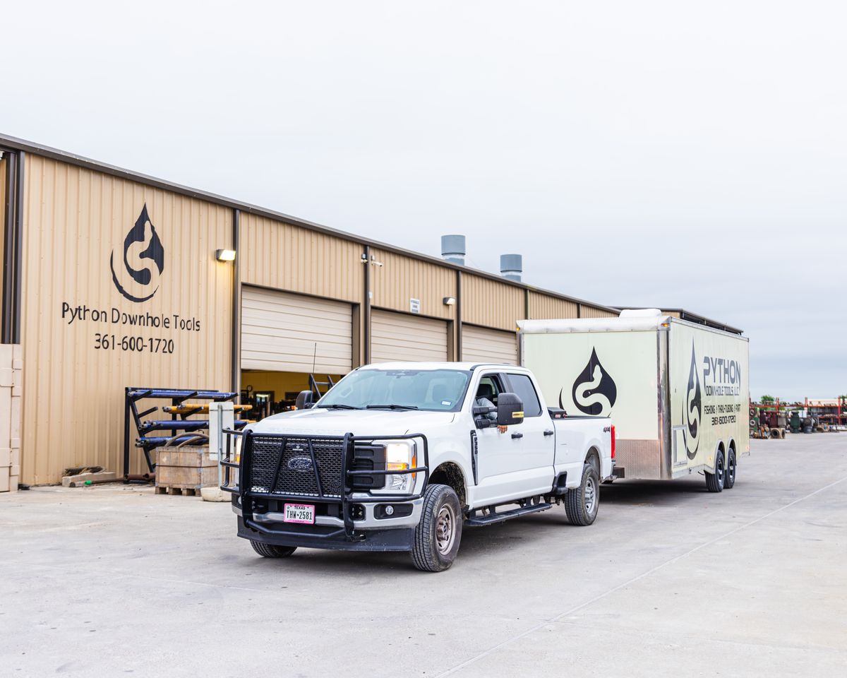 A branded Python Downhole Tools Ford Super Duty truck and enclosed trailer parked outside the company's Corpus Christi shop, the building marked with the Python logo and 361-600-1720.
